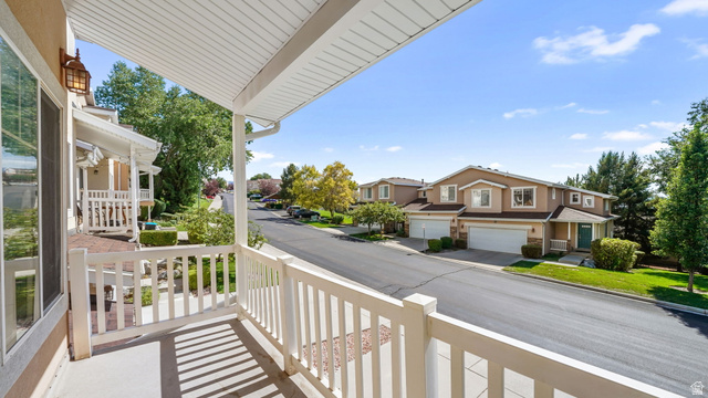 1285 Alpine Way Provo, UT 84606 - Photo 14 of 25 Covered porch with white railings, a mounted exterior light fixture, and large windows