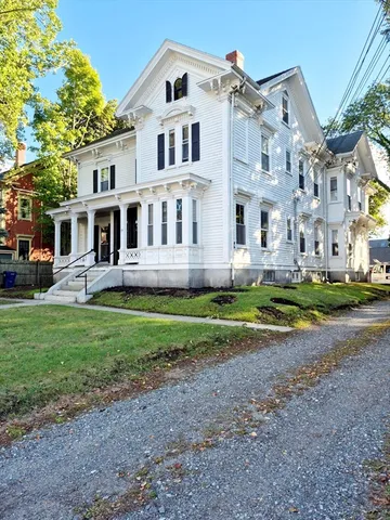 a front view of a house with a yard and trees