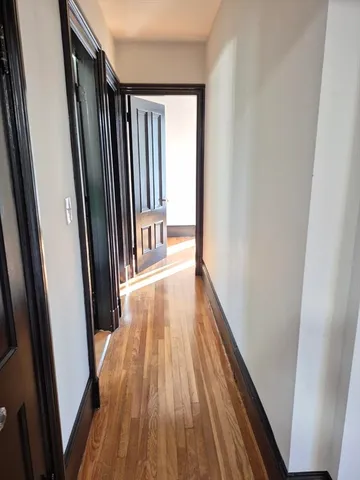 a view of a hallway with wooden floor and staircase
