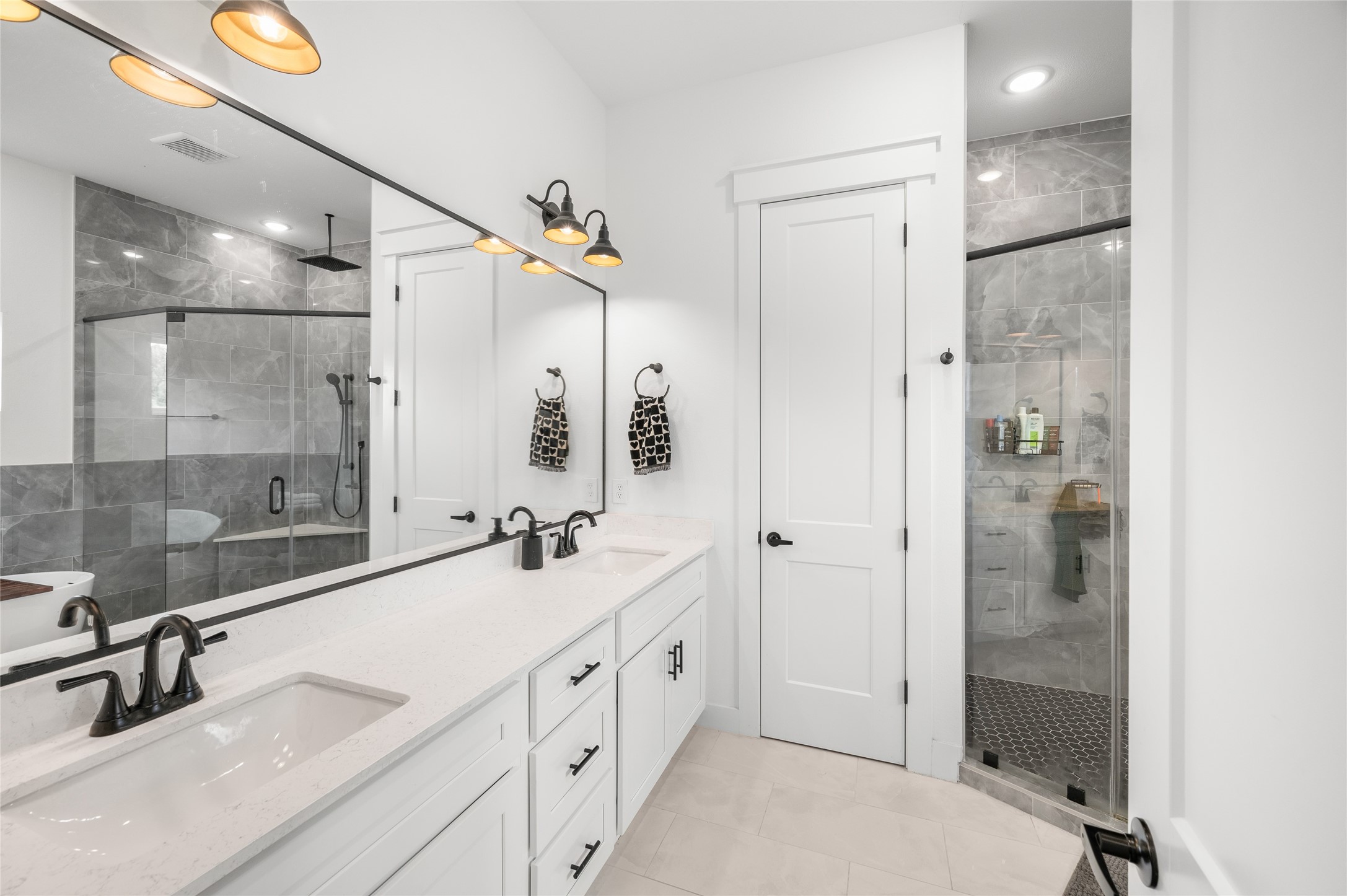4603 Terry Street Houston, TX 77009 - Photo 28 of 41 Primary bathroom featuring a spacious double vanity with modern fixtures, a sleek glass-enclosed shower, and stylish tilework for a luxurious feel.