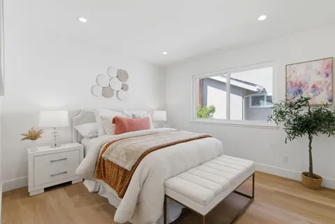 a bedroom with a bed and a potted plant