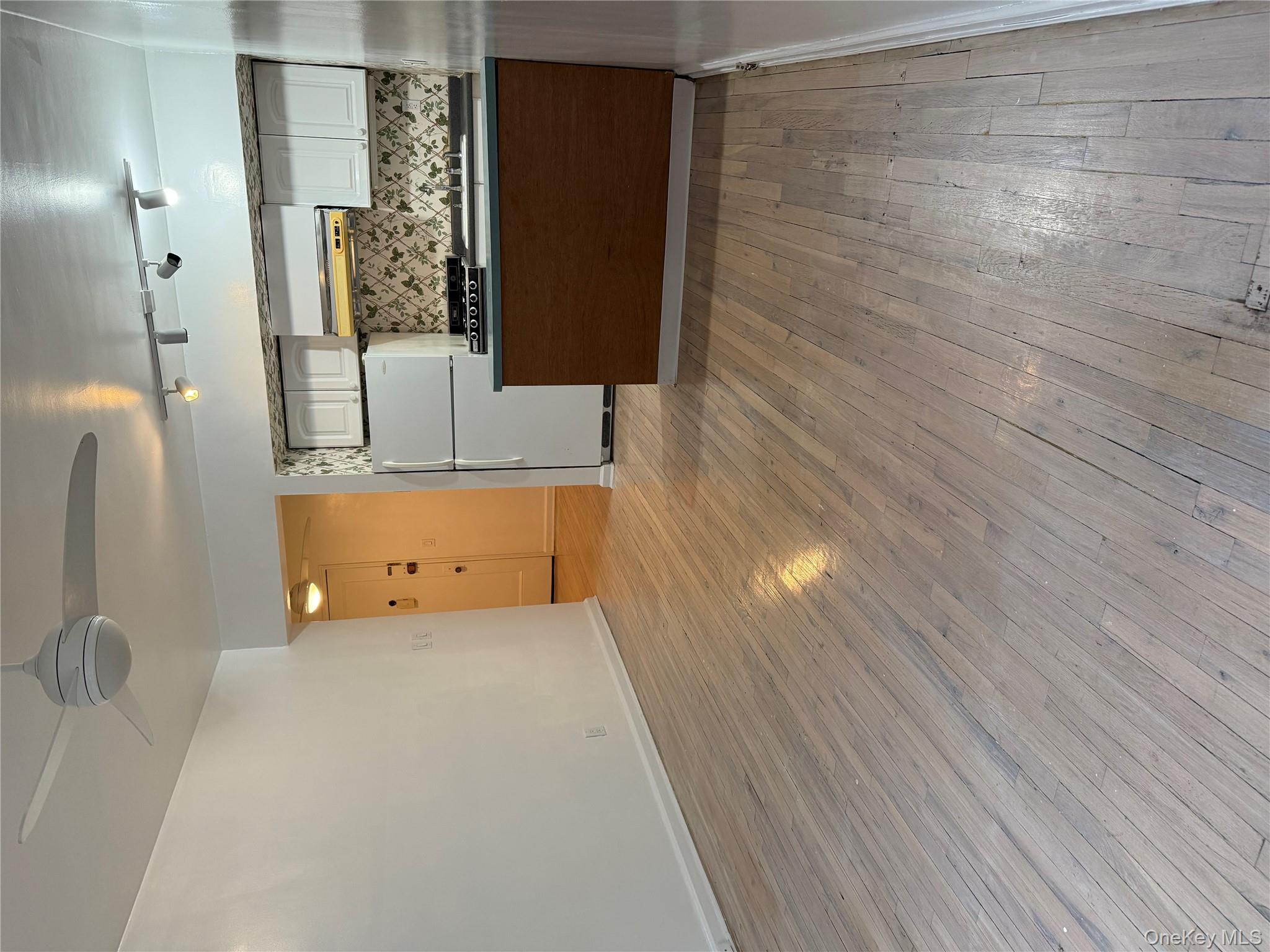 15 Canterbury Road, Unit D13 Great Neck, NY 11021 - Photo 10 of 10 Kitchen with open floor plan, tasteful backsplash, fridge, and light wood-style floors