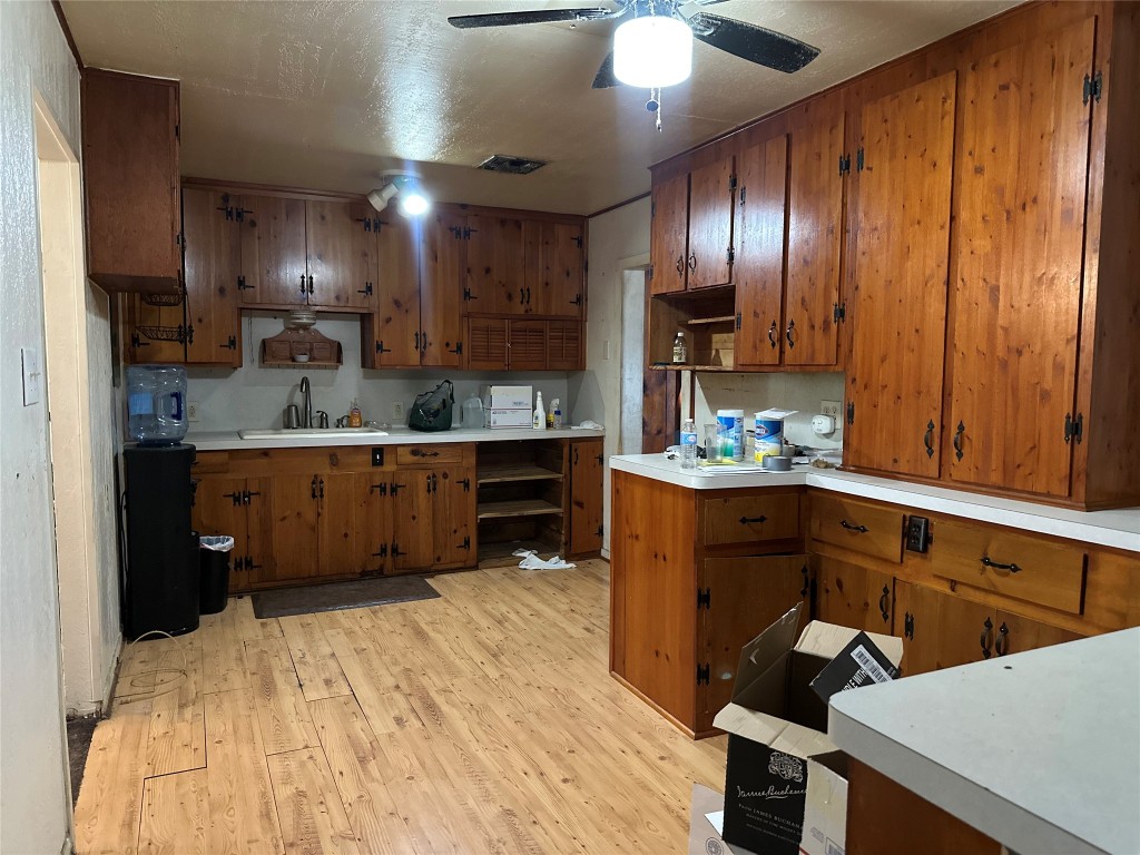 1001 Red Bud Street Channelview, TX 77530 - Photo 9 of 21 a kitchen with stainless steel appliances kitchen island granite countertop a refrigerator a sink dishwasher and wooden cabinets with wooden floor