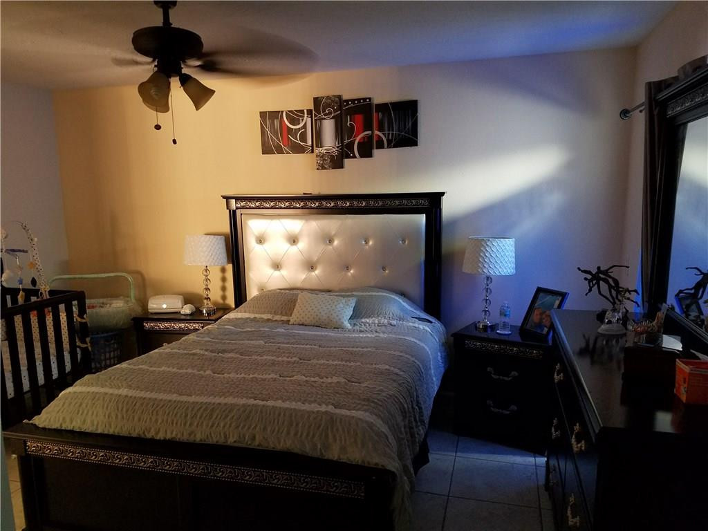 11229 Southwest 152nd Terrace Miami, FL 33157 - Photo 26 of 26 a bedroom with a bed and a chandelier