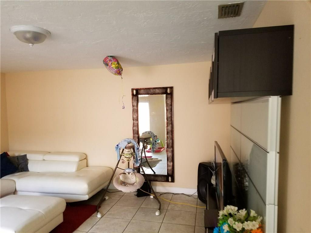 11229 Southwest 152nd Terrace Miami, FL 33157 - Photo 7 of 26 a living room with furniture and a flat screen tv