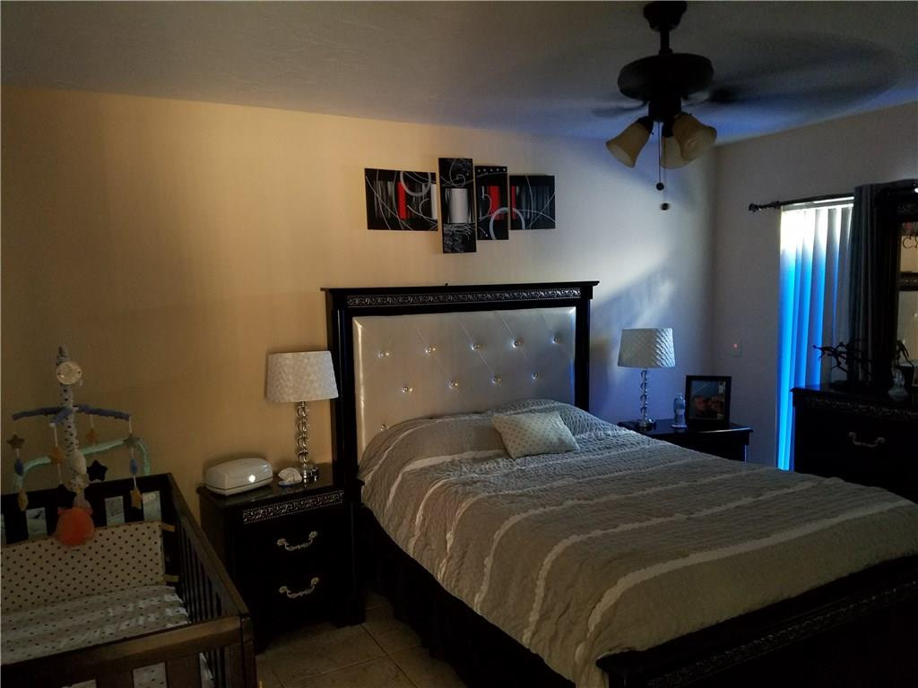 11229 Southwest 152nd Terrace Miami, FL 33157 - Photo 9 of 26 a bedroom with a bed and a chandelier