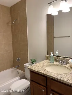 a bathroom with a granite countertop sink a toilet and bathtub