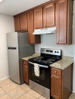 a kitchen with stainless steel appliances granite countertop a stove a refrigerator and a cabinets