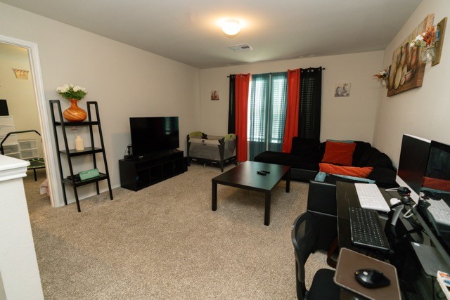 23123 Barrington Bluff Trail Spring, TX 77373 - Photo 35 of 50 a living room with furniture a flat screen tv and gym equipment
