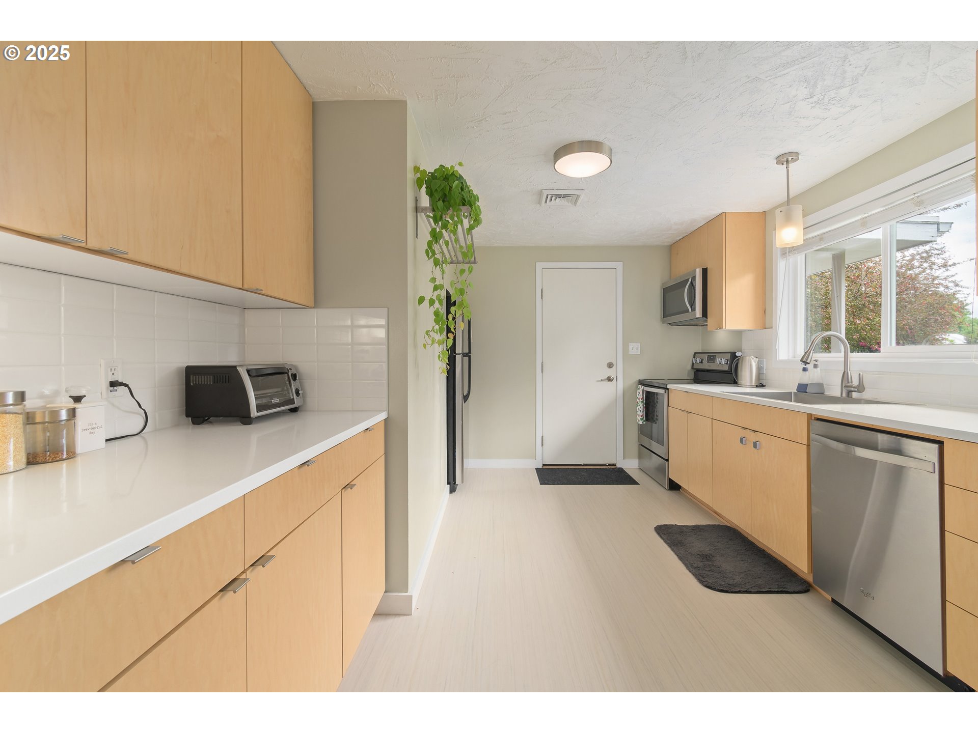 3417 Harlow Road Eugene, OR 97401 - Photo 6 of 40 a kitchen with a sink dishwasher and white cabinets