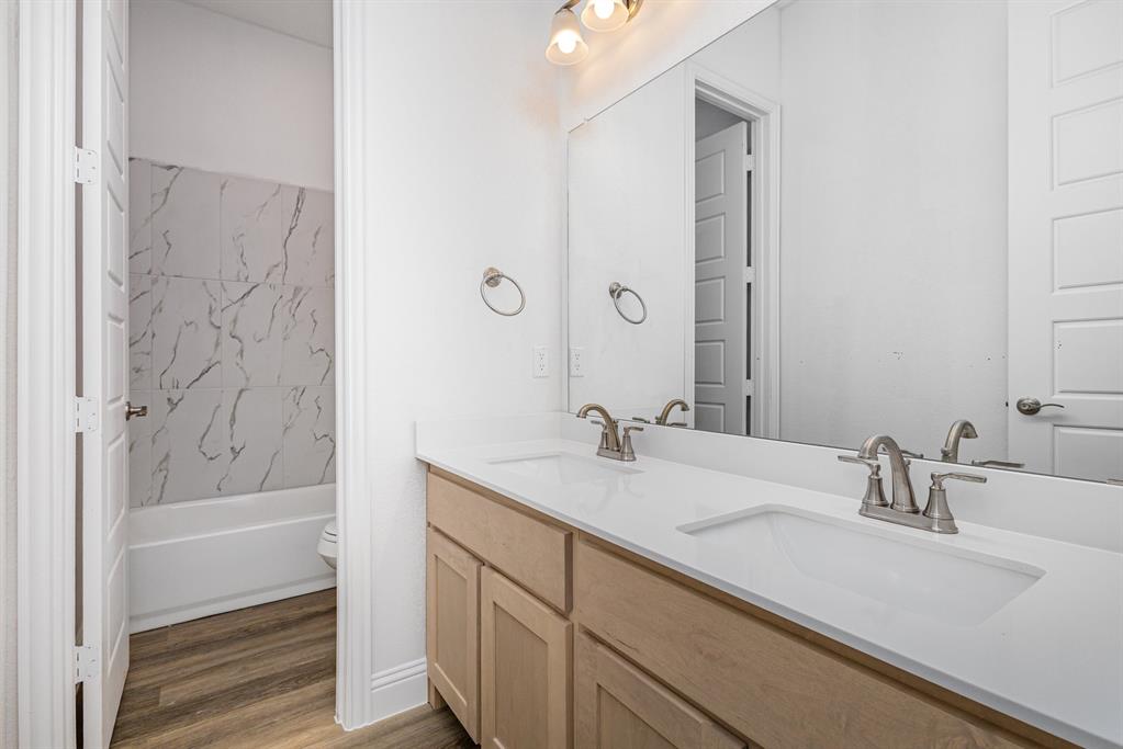 6044 Mango Drive Sanger, TX 76266 - Photo 14 of 27 a bathroom with a granite countertop sink and a mirror