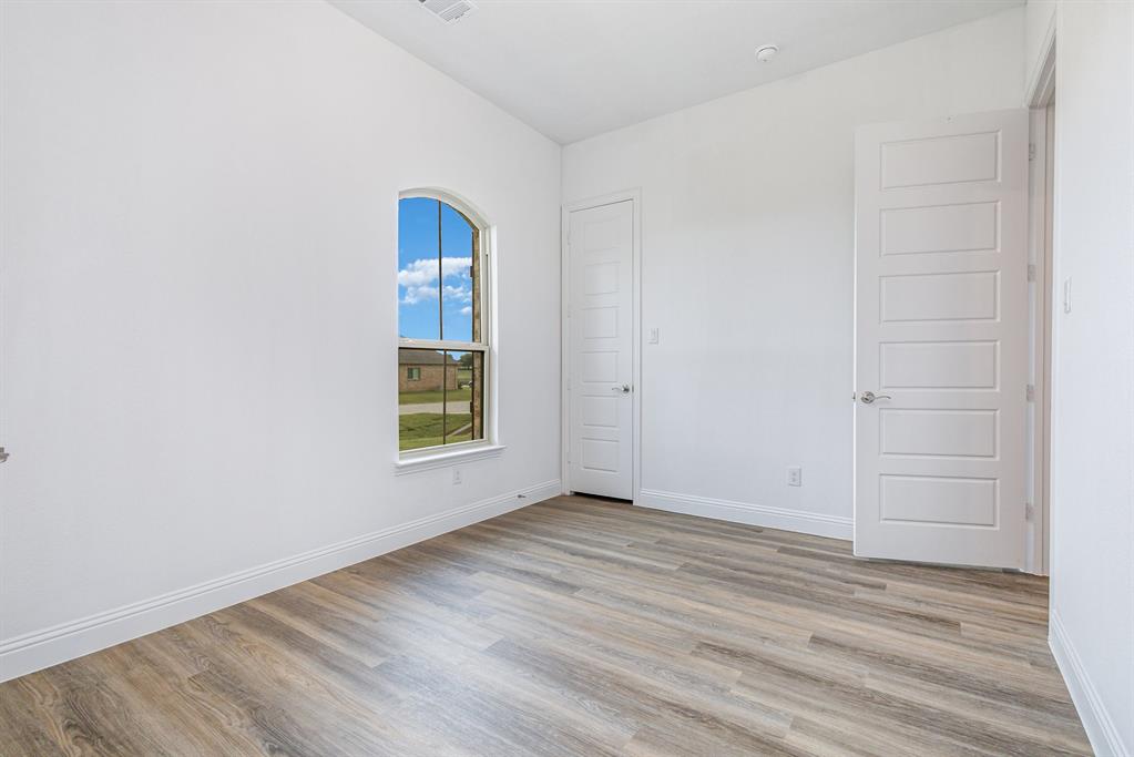 6044 Mango Drive Sanger, TX 76266 - Photo 16 of 27 an empty room with wooden floor and windows