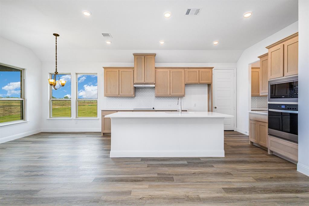 6044 Mango Drive Sanger, TX 76266 - Photo 24 of 27 a view of kitchen with stainless steel appliances granite countertop a stove and a sink