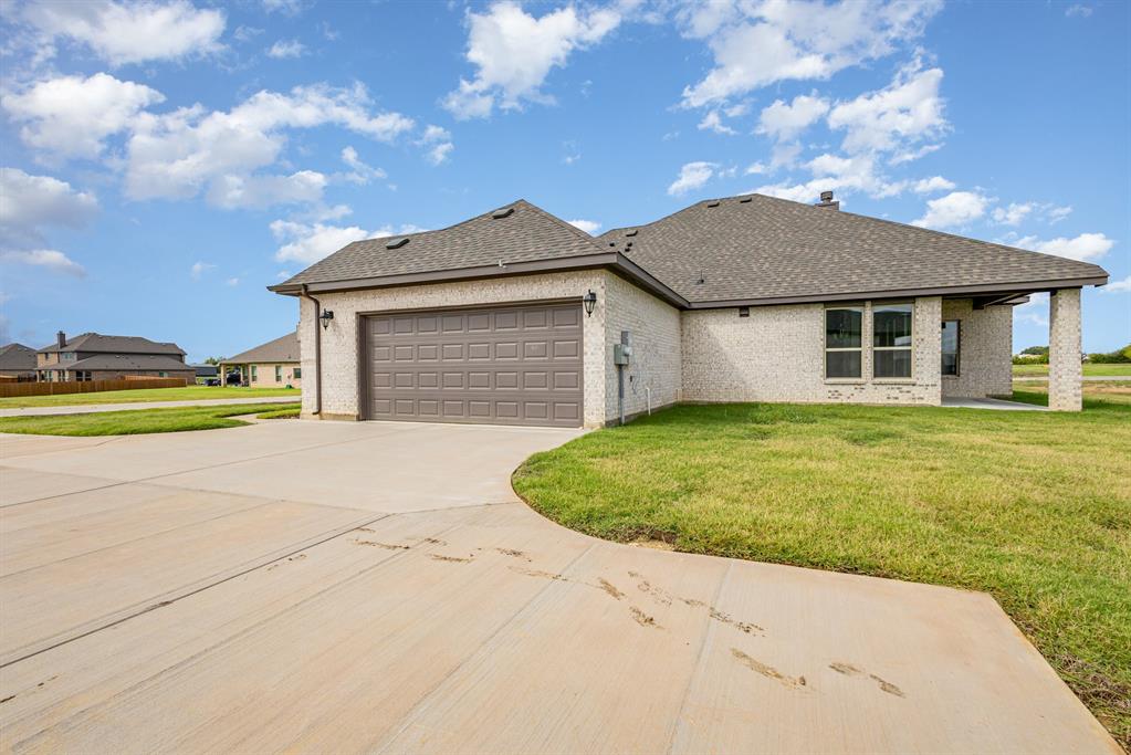 6044 Mango Drive Sanger, TX 76266 - Photo 25 of 27 a front view of a house with a garden and pathway