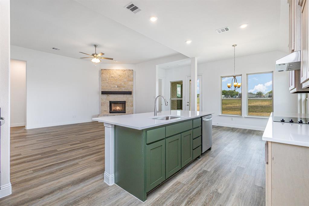 6044 Mango Drive Sanger, TX 76266 - Photo 5 of 27 a kitchen with kitchen island a sink appliances and a window