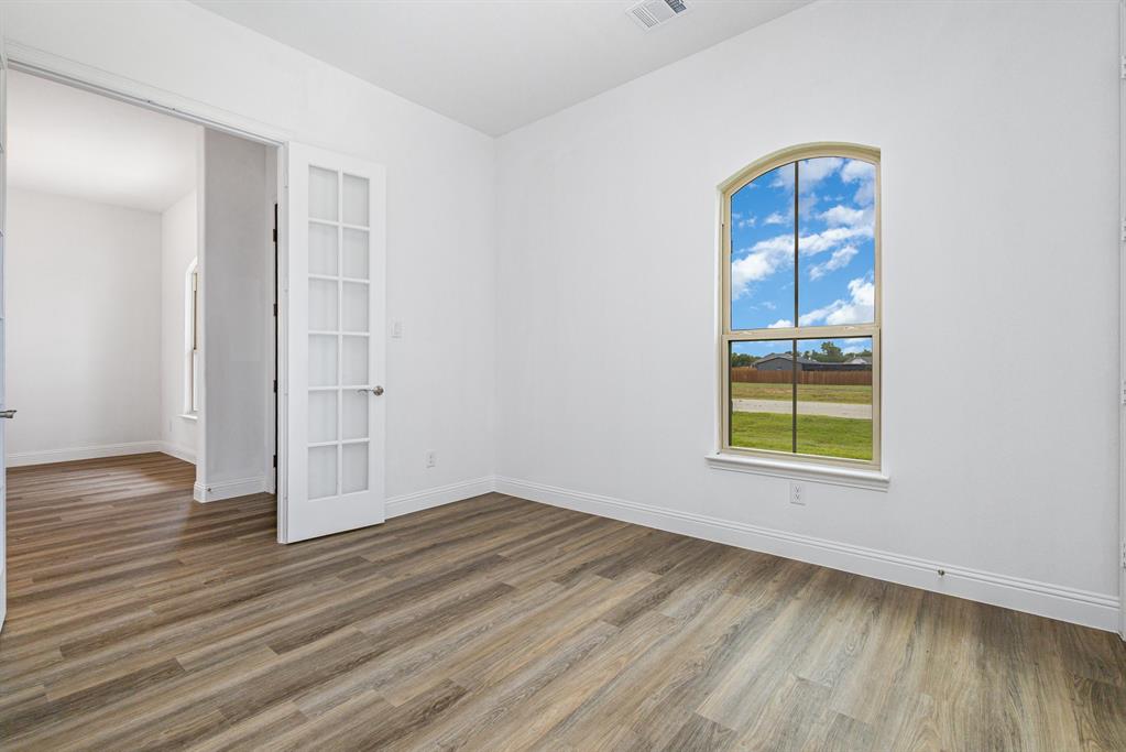 6044 Mango Drive Sanger, TX 76266 - Photo 7 of 27 an empty room with wooden floor closet and windows