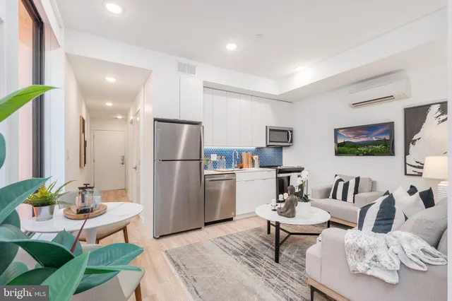 a living room with furniture and a kitchen view