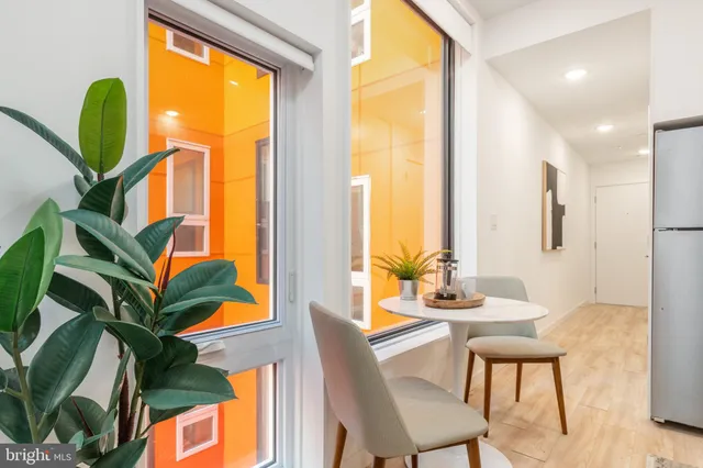a dining room with furniture and a potted plant