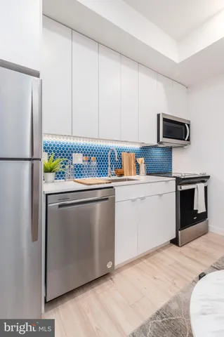 a kitchen with stainless steel appliances a refrigerator sink and microwave