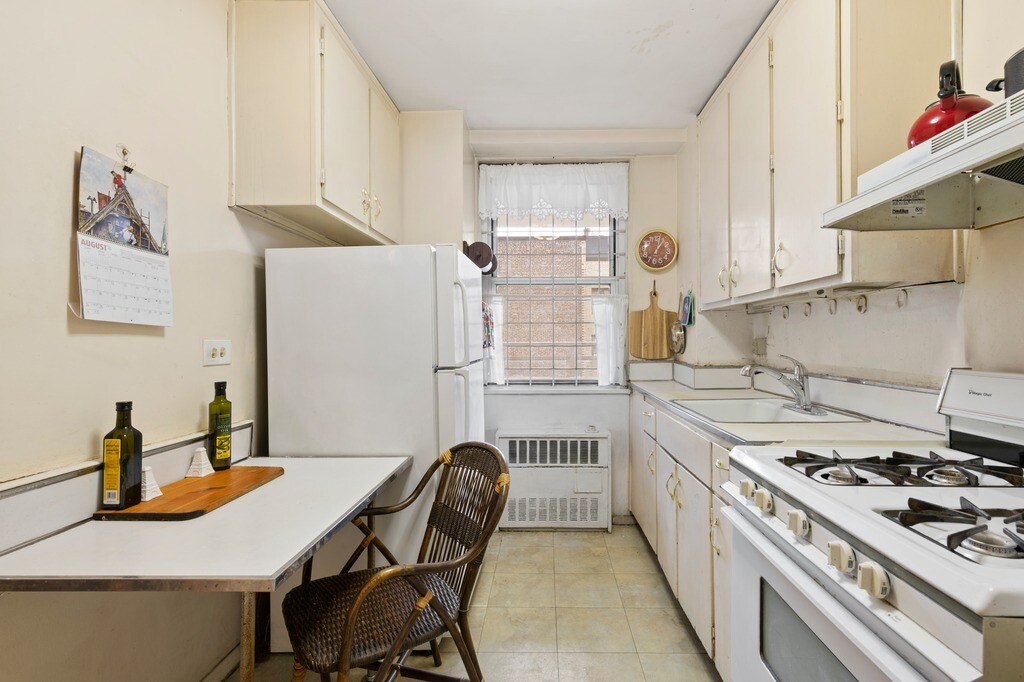 100 West 94th Street, Unit 5C Manhattan, NY 10025 - Photo 4 of 7 a kitchen with a stove and white cabinets