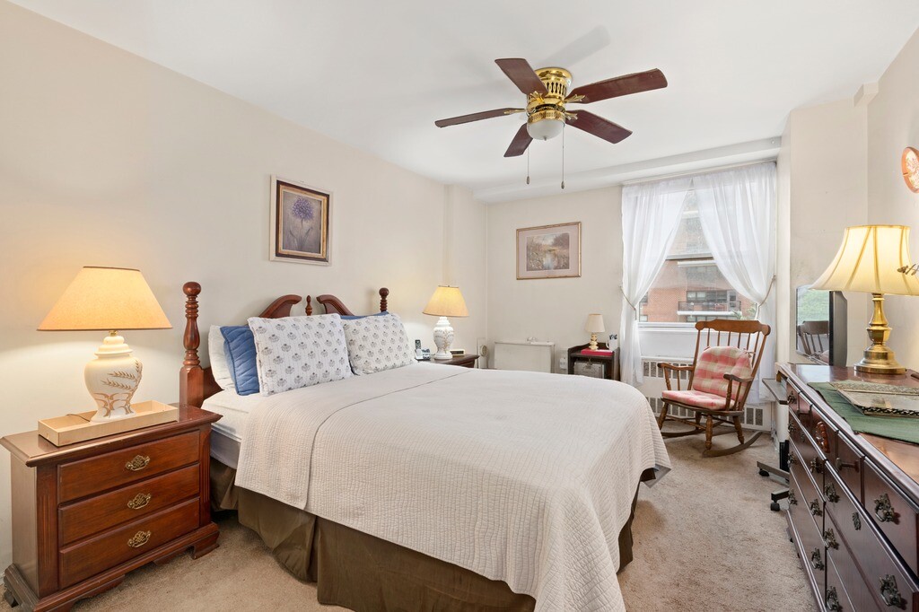 100 West 94th Street, Unit 5C Manhattan, NY 10025 - Photo 5 of 7 a bedroom with a bed and a chandelier