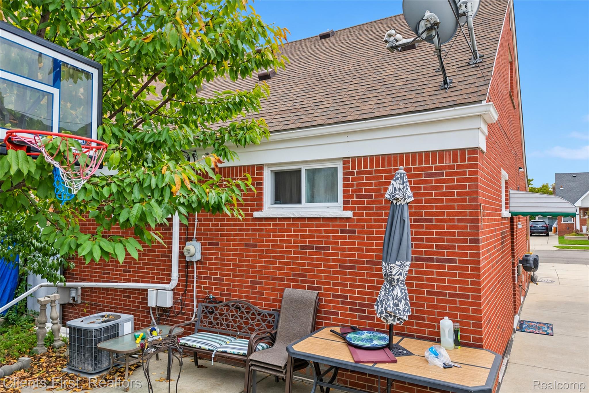 5430 Chase Road Dearborn, MI 48126 - Photo 26 of 34 Red brick exterior with white trim, brown shingle roofing, and a concrete side yard