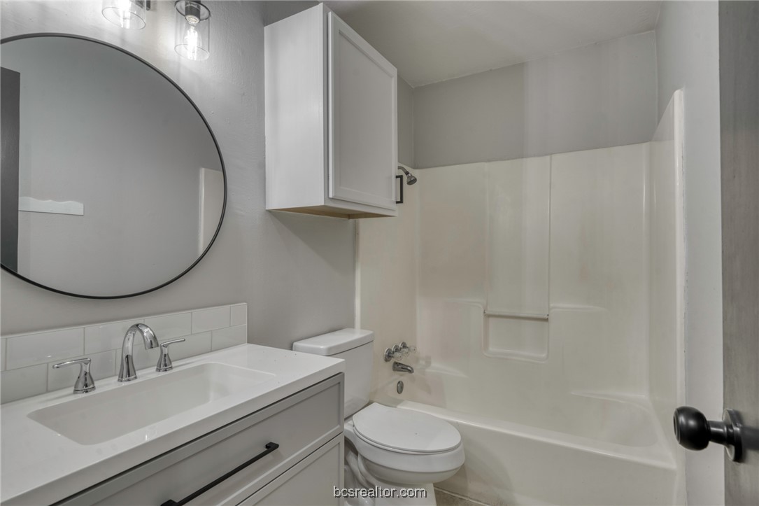 1203 Spring Loop, Unit A College Station, TX 77840 - Photo 10 of 13 Full bathroom with vanity, washtub / shower combination, and toilet