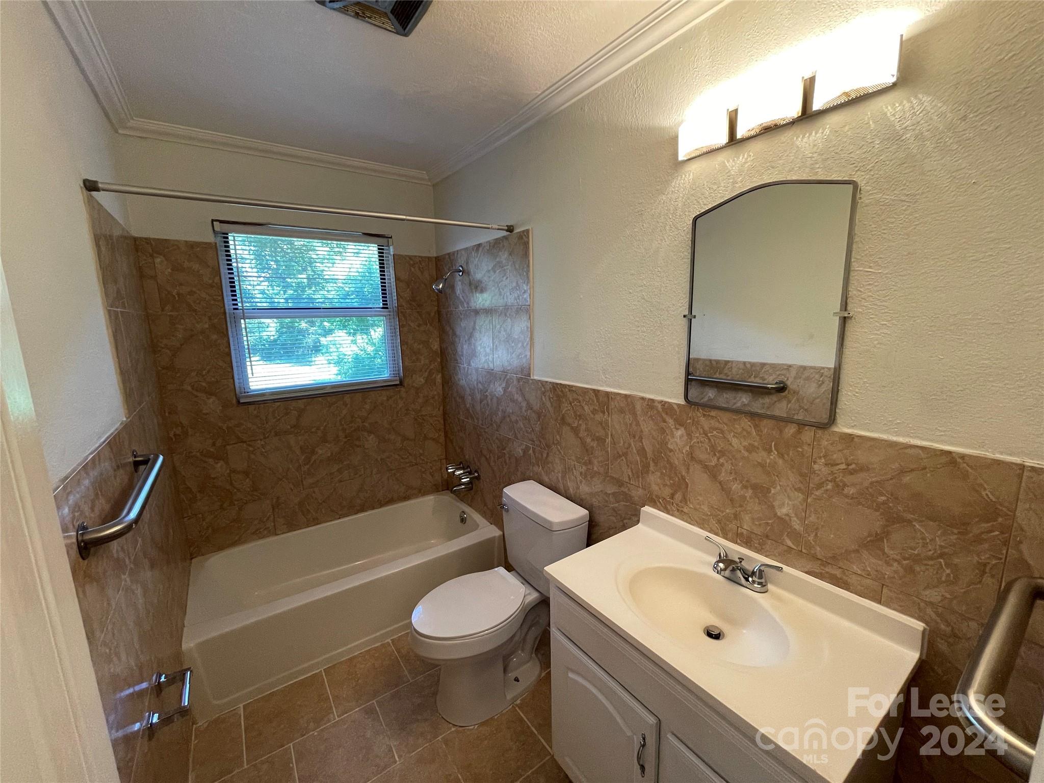 7228 Tuckaseegee Road, Unit A Charlotte, NC 28214 - Photo 2 of 7 a bathroom with a sink a toilet and bathtub
