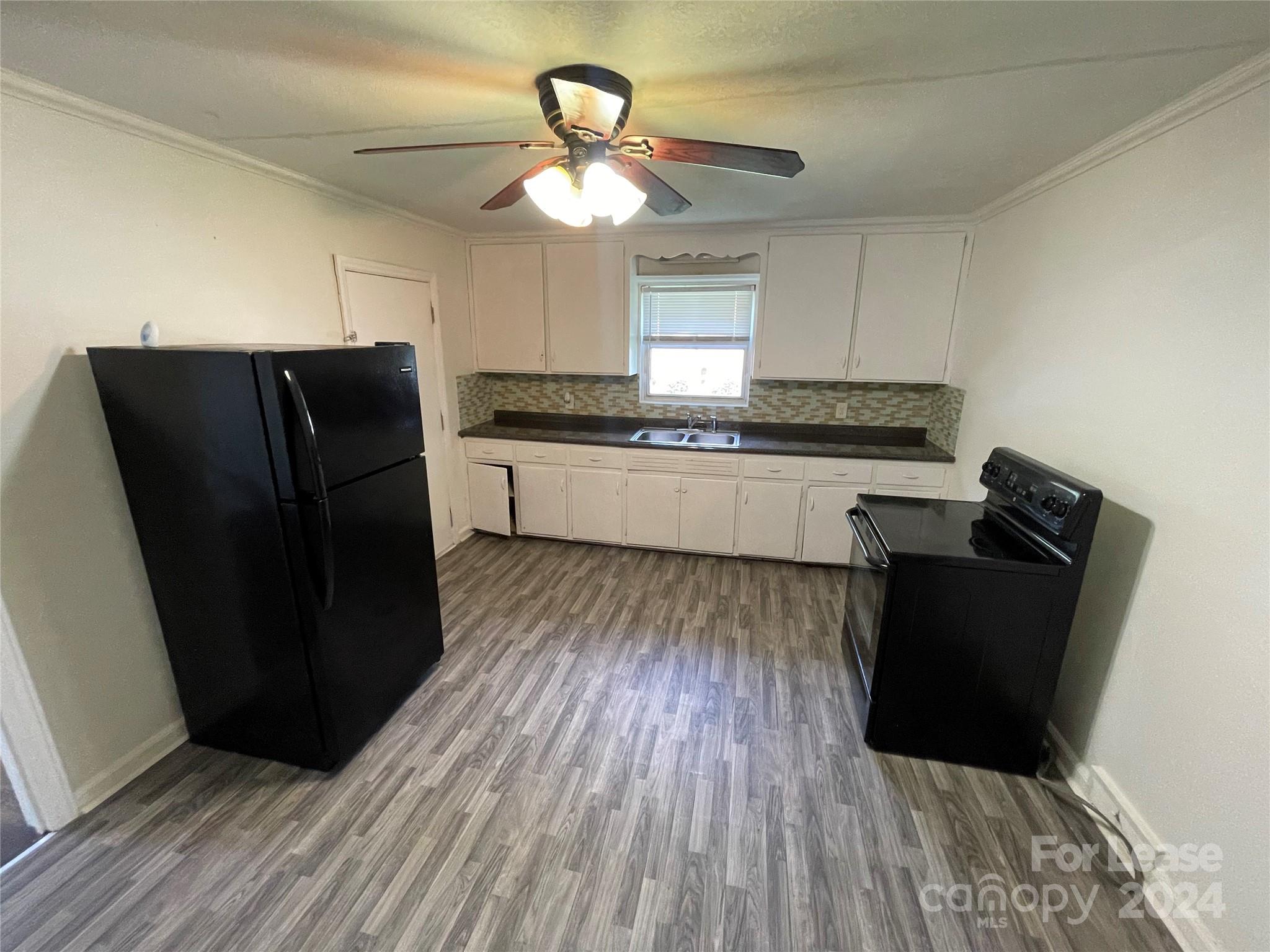 7228 Tuckaseegee Road, Unit A Charlotte, NC 28214 - Photo 5 of 7 a kitchen with a refrigerator and wooden floor