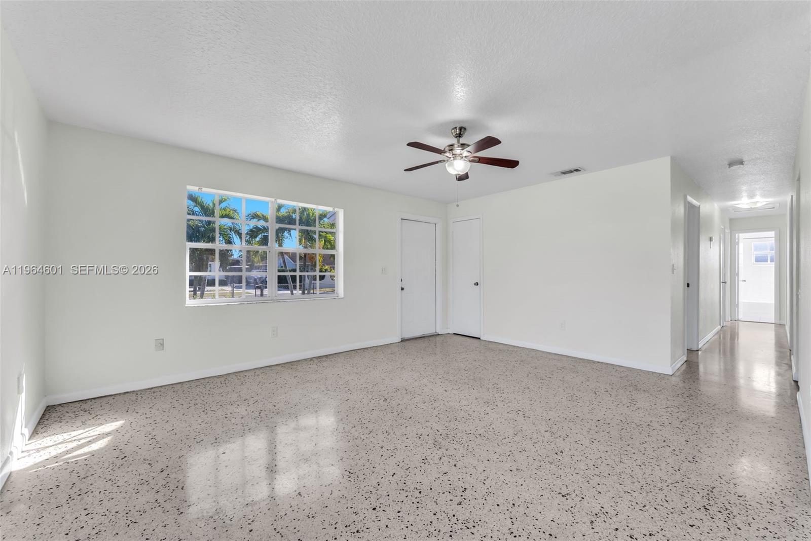 15231 Southwest 302nd Street Homestead, FL 33033 - Photo 7 of 30 an empty room with windows and chandelier fan