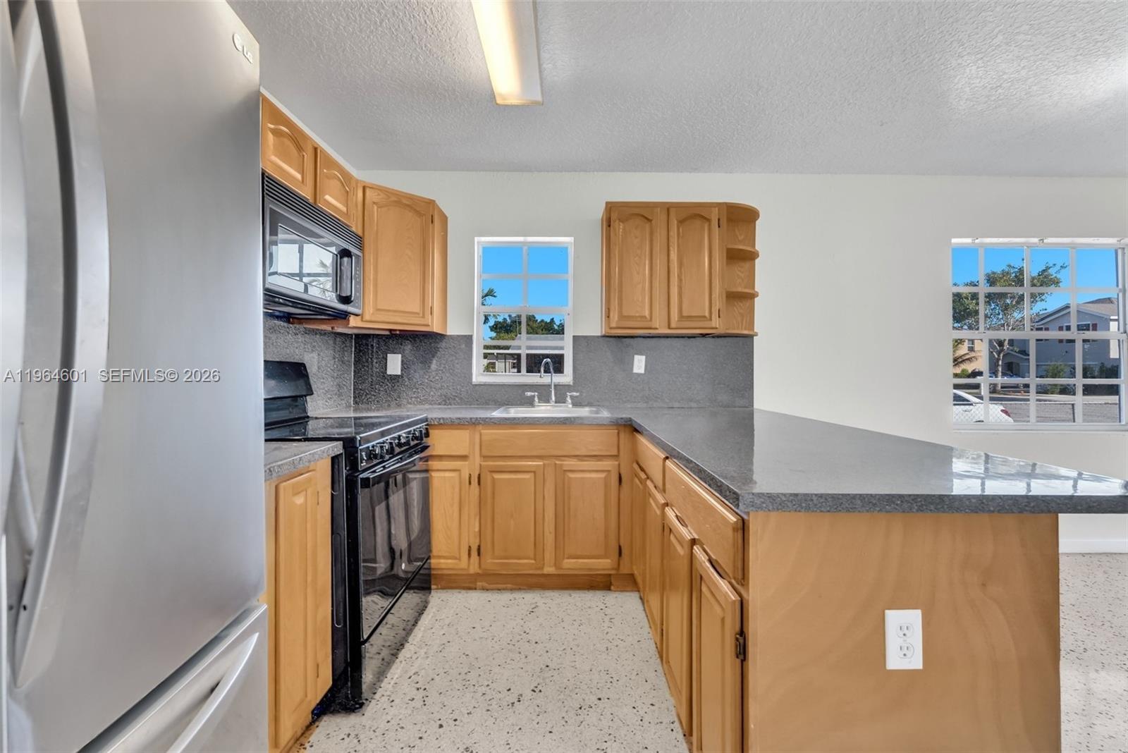 15231 Southwest 302nd Street Homestead, FL 33033 - Photo 8 of 30 a kitchen with stainless steel appliances granite countertop a stove a sink and a refrigerator