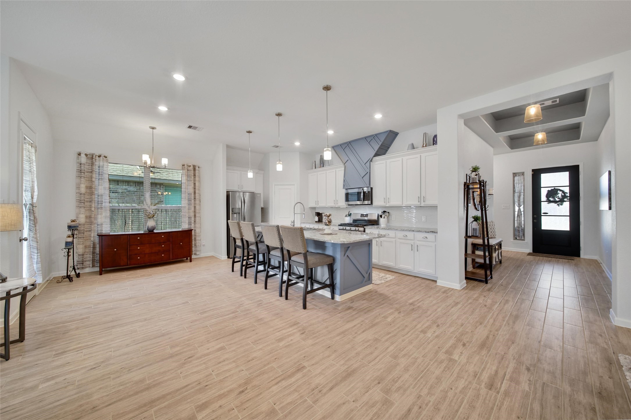 3422 Warwick River Trail Houston, TX 77365 - Photo 10 of 46 a kitchen with stainless steel appliances kitchen island granite countertop a refrigerator a stove a sink a dining table and chairs with wooden floor