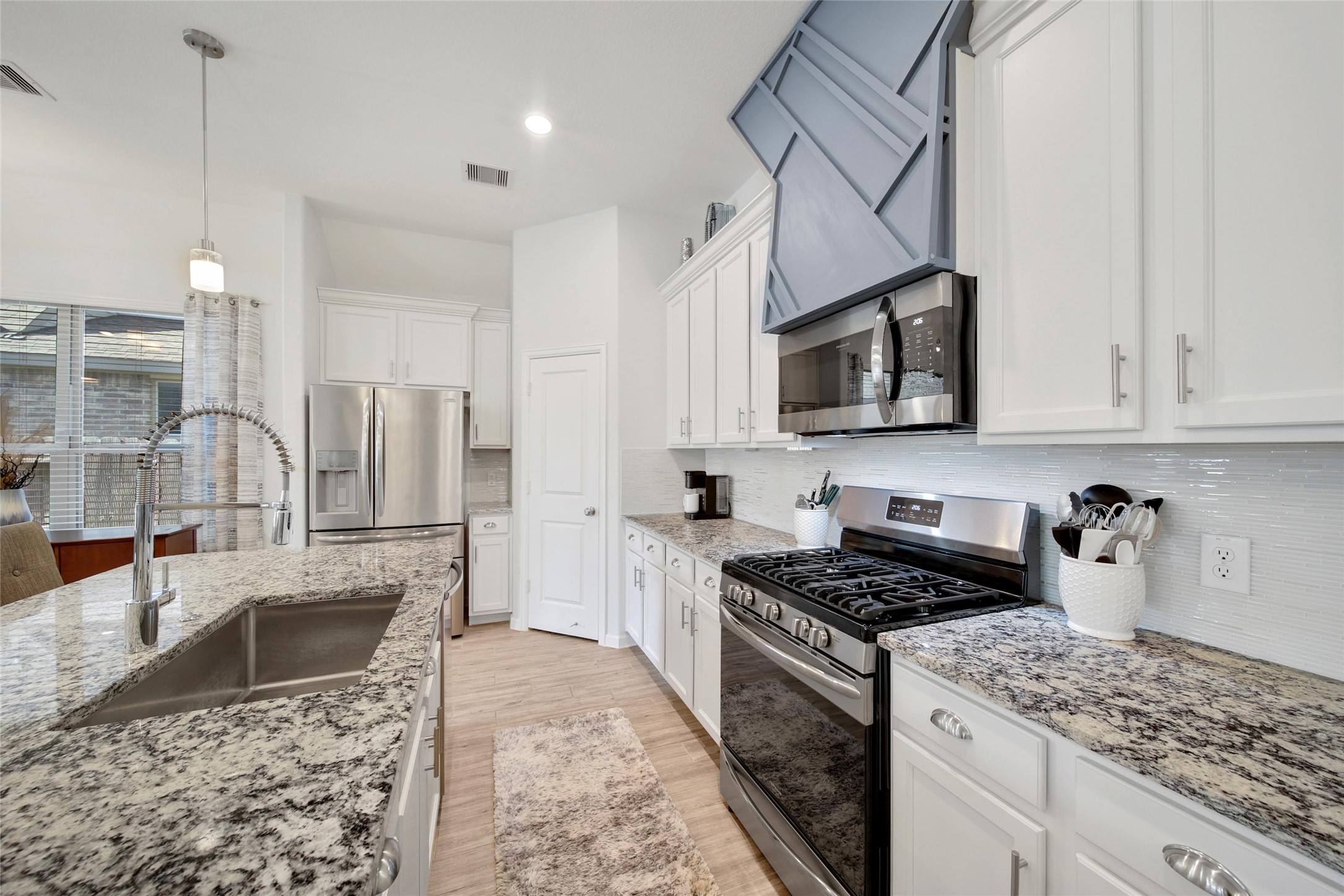 3422 Warwick River Trail Houston, TX 77365 - Photo 13 of 46 a kitchen with stainless steel appliances granite countertop a sink a stove top oven a counter space and cabinets