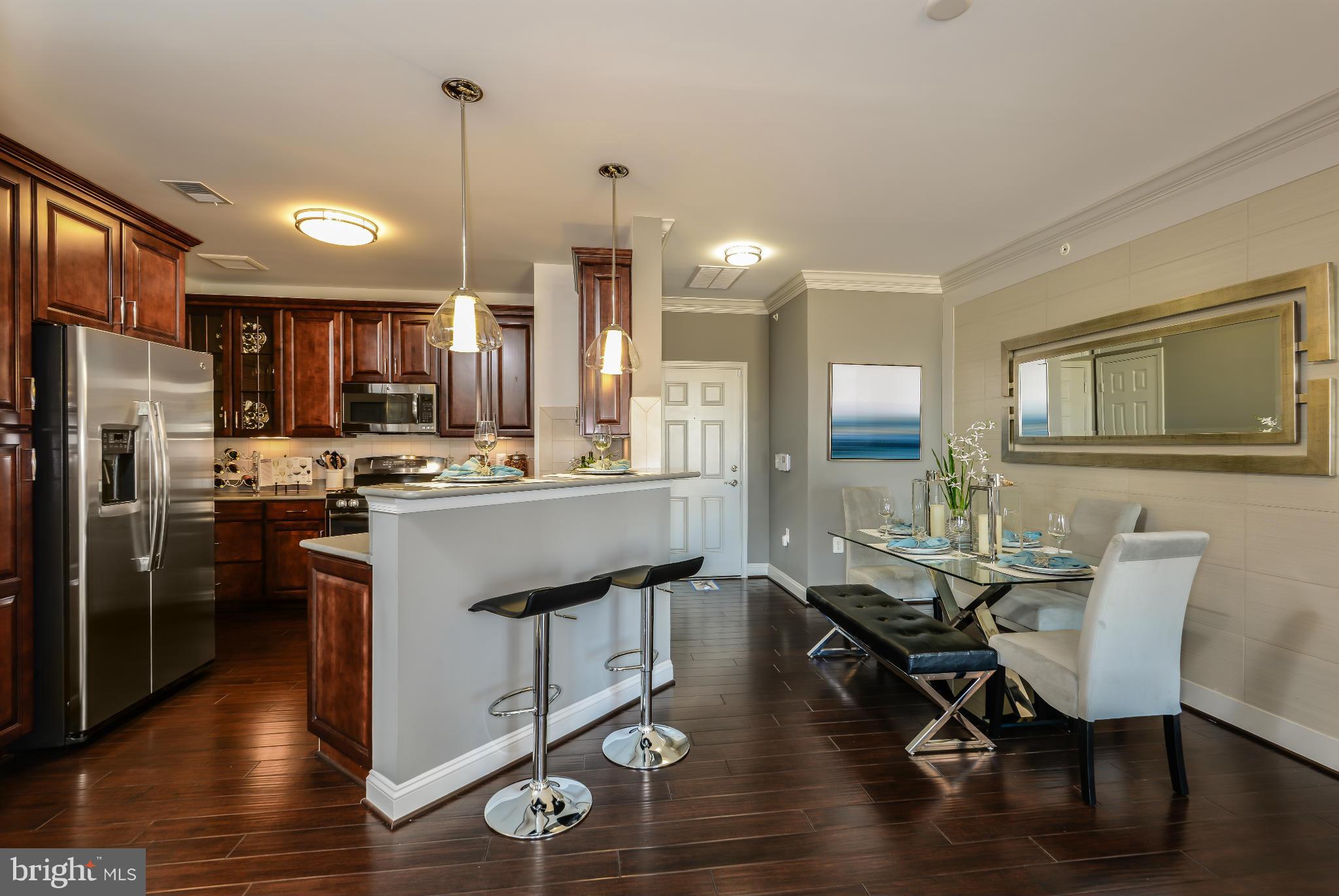 3750 Clara Downey Avenue, Unit 35 Silver Spring, MD 20906 - Photo 2 of 14 a kitchen with counter space dining table and stainless steel appliances
