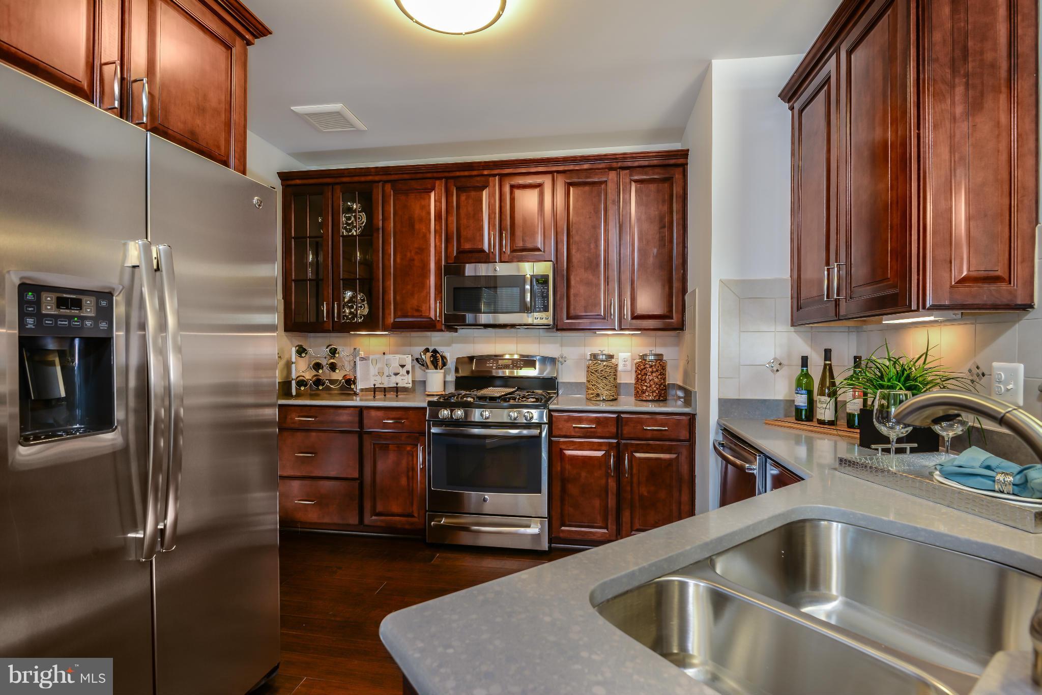 3750 Clara Downey Avenue, Unit 35 Silver Spring, MD 20906 - Photo 3 of 14 a kitchen with stainless steel appliances granite countertop a refrigerator sink and stove