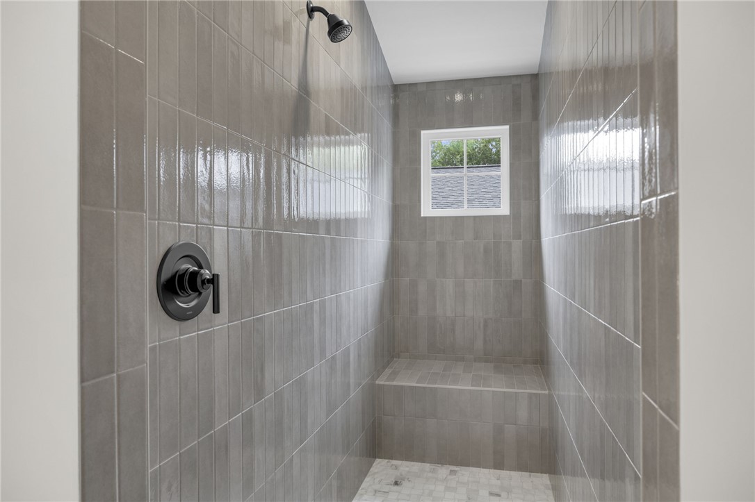 1230 Melton Road, Unit 216 West Union, SC 29696 - Photo 30 of 49 A windowed walk-in shower features integrated seating and sleek tile finishes.