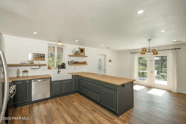 an empty room with wooden floor and ceiling fan
