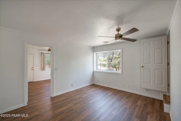 a kitchen with stainless steel appliances granite countertop a refrigerator a sink dishwasher a microwave oven and a dining table with wooden floor