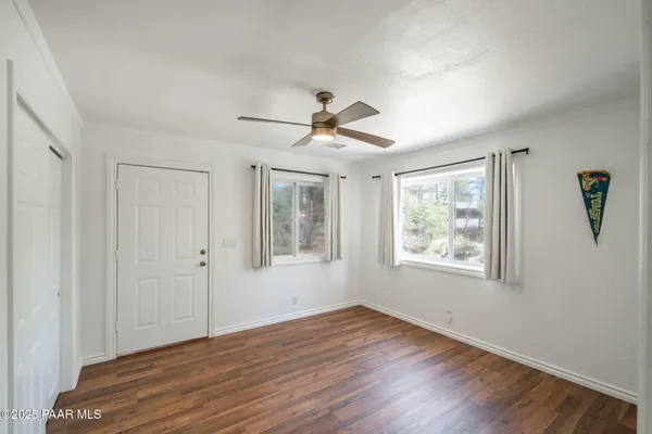 a view of a livingroom with wooden floor and a ceiling fan