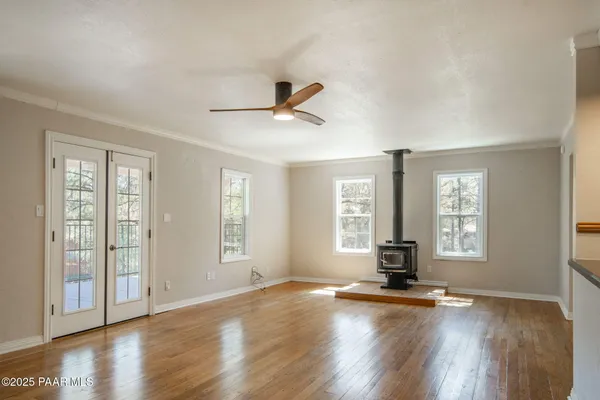 a view of a livingroom with wooden floor and a ceiling fan
