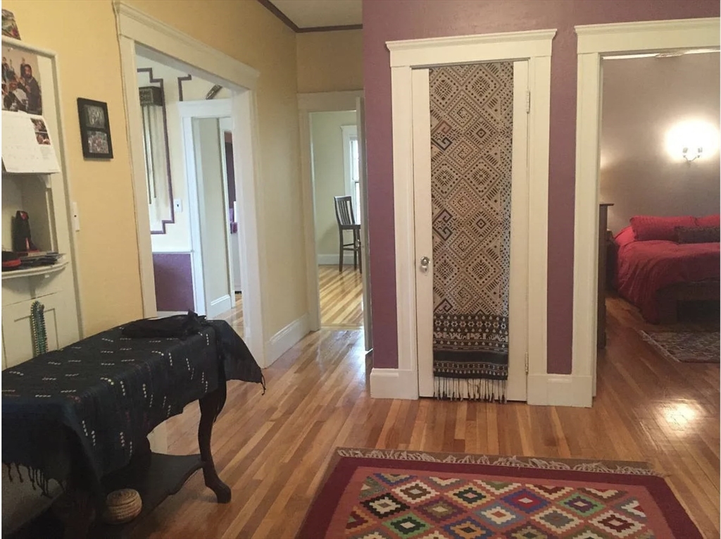 30 Lawrence Street, Unit 2 Everett, MA 02149 - Photo 4 of 13 a bedroom with a bed and a wooden floor