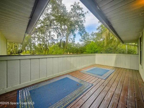 a view of balcony with wooden floor and fence