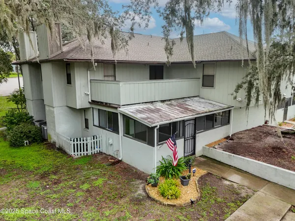 an aerial view of a house with a yard fountain and a large tree