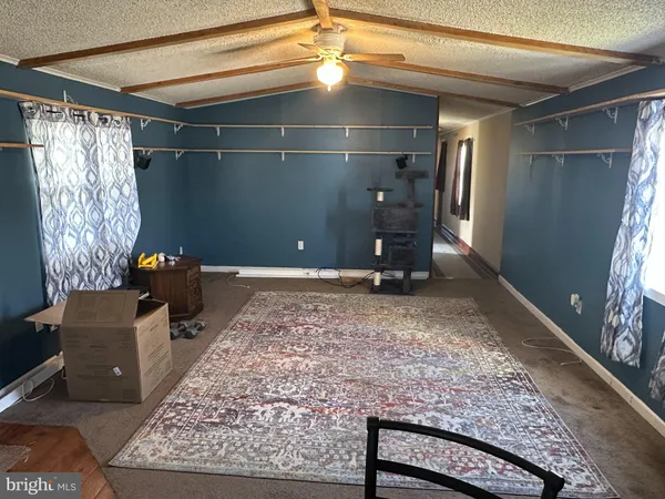 a living room with couches a dining table and chairs with wooden floor