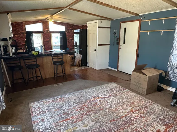 a kitchen with stainless steel appliances a table chairs refrigerator and cabinets