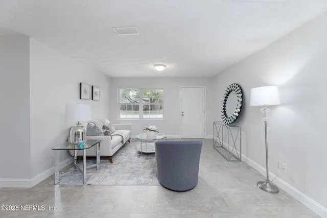 a living room with furniture a window and a lamp