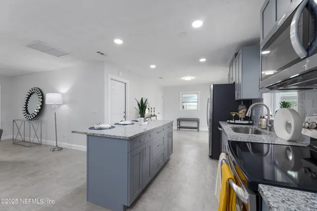 a kitchen with stainless steel appliances granite countertop a sink stove and refrigerator