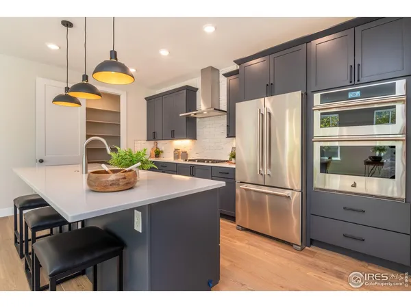 a kitchen with refrigerator cabinets and wooden floor