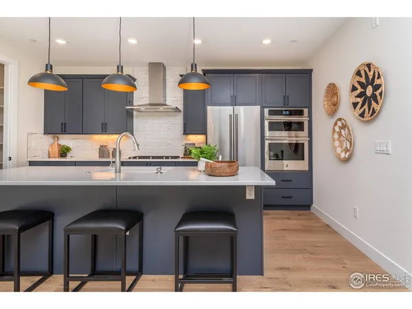 a kitchen with stainless steel appliances granite countertop a sink and a refrigerator