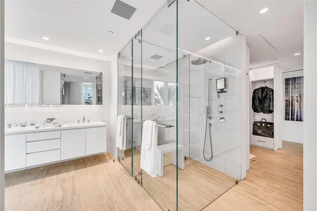 a spacious bathroom with a glass shower door and a sink